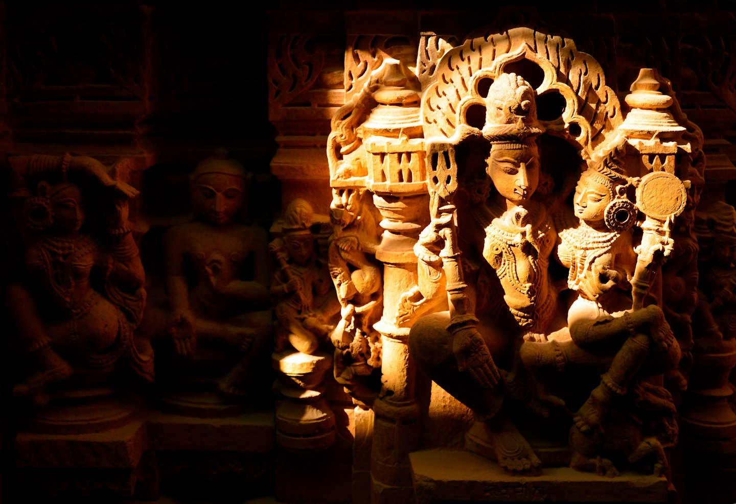 Detailed ancient stone carvings of figures inside a temple.