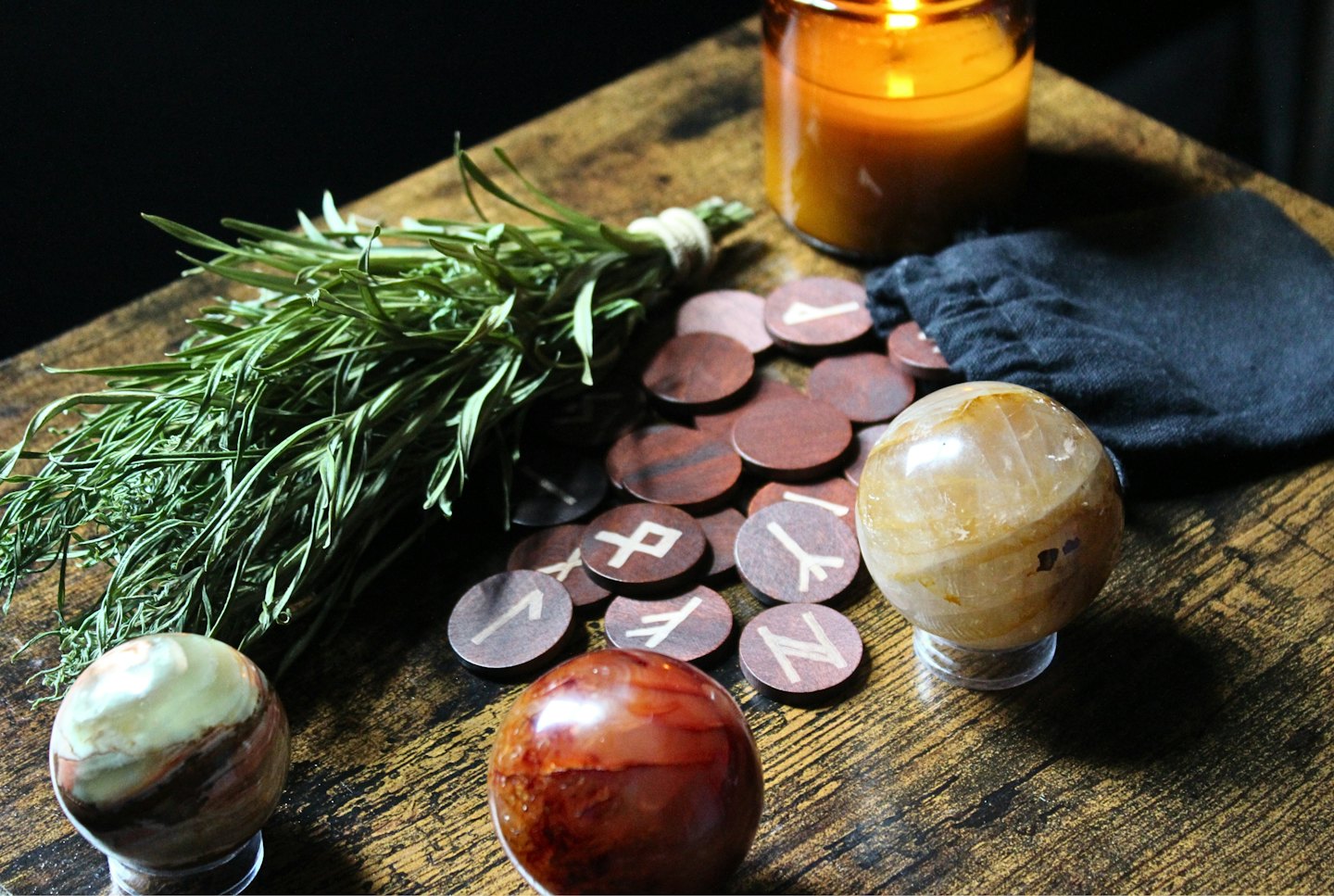 Herbs and runes on wooden discs with crystal orbs.