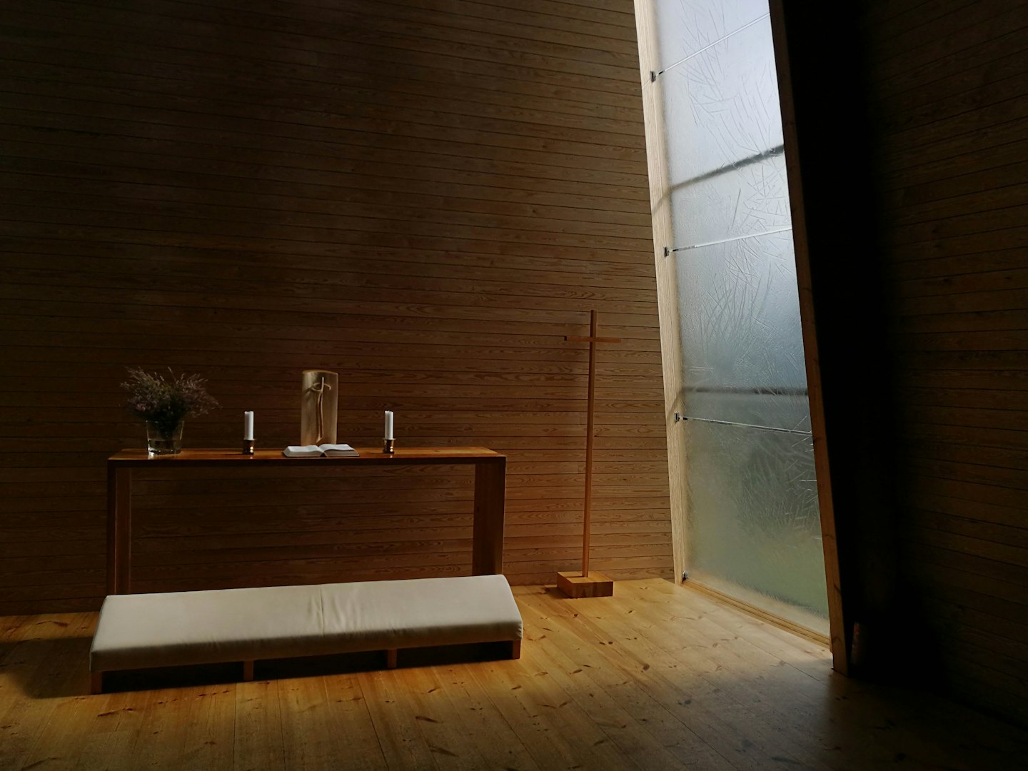 Candles and an open book sit on a wooden console table.